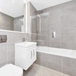 Modern bathroom with grey tiles and white fixtures