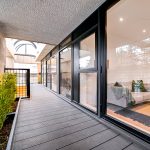 Modern balcony with glass doors and plants.