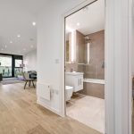 Modern bathroom and living room interior with wooden flooring.