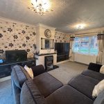 Cosy living room with floral wallpaper and sofa.