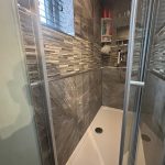 Modern tiled shower with glass doors