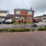 Detached house with cars in driveway.