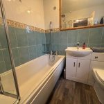 Modern bathroom with bathtub, sink, and toilet.