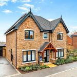 Modern detached house with driveway and garden.