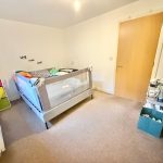 Child's bedroom with bed and shelving unit.