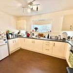 Modern kitchen with appliances and white cabinets.
