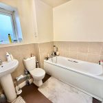 Modern bathroom with bath, sink, and toilet.