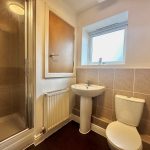 Modern bathroom with shower, sink, and toilet.