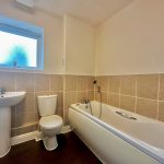 Modern bathroom with bathtub, sink, and toilet