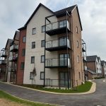 Modern apartment buildings with balconies and pathway.