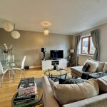 Modern living room with beige sofas and TV.