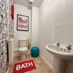 Comic-themed bathroom with sink and toilet.