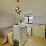 Cosy bedroom with elegant chandelier and dresser.