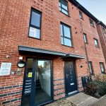 Brick building with modern entrance and flat listings.