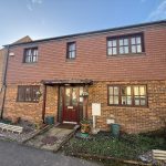 Two-storey brick house with a red tiled roof.