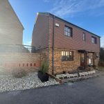 Two-storey brick house with garden and driveway.