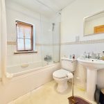 Modern bathroom with bathtub, sink, and toilet.