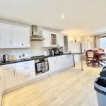 Modern kitchen and dining area with wooden flooring.