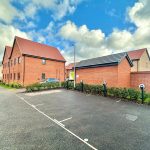 Modern brick houses with parking and charging stations.