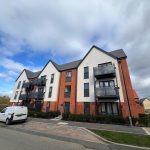 Modern apartment building with red brick facade.