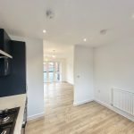 Modern kitchen and dining area with wooden flooring.