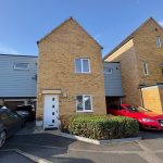 Modern brick house with parked cars and driveway.