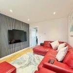 Modern living room with red sofas and TV.