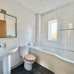 Modern white bathroom with bath and sink.