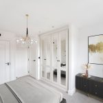 Modern bedroom with wardrobe and decorative artwork.