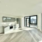 Modern kitchen with large windows and balcony view.