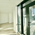 Bright empty room with balcony and large windows.