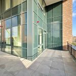 Modern glass balcony with city view.