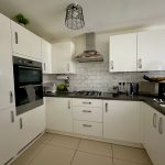 Modern white kitchen with sleek design and appliances.