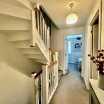 Modern hallway with stairs and decorative vase.
