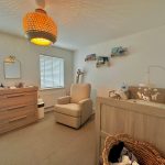 Cosy nursery room with crib and armchair.