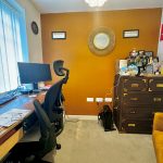 Home office with desk, chairs, and storage cabinet.