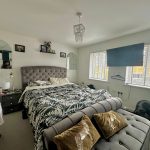 Modern bedroom with large bed and decorative pillows.