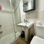 Modern bathroom with shower, sink, and toilet.