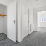 Modern carpeted hallway with open closet door