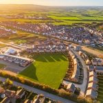 Aerial view of housing estate and green fields.