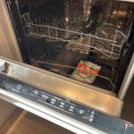 Open dishwasher with detergent packet inside.