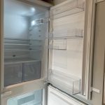 Open empty refrigerator with shelves and drawers.