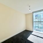 Bright empty room with large window and carpet