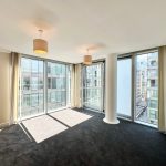 Modern empty room with large windows, natural light.