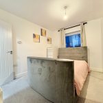 Modern bedroom with grey bed and artwork