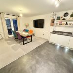 Modern dining area with colourful chairs and kitchen.
