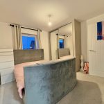 Modern bedroom with grey and pink decor.