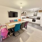 Modern kitchen-diner with colourful chairs and pram