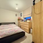 Cosy bedroom with bed, wardrobe, and toys.