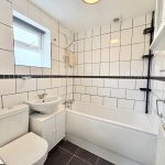 Modern bathroom with white tiles and bath